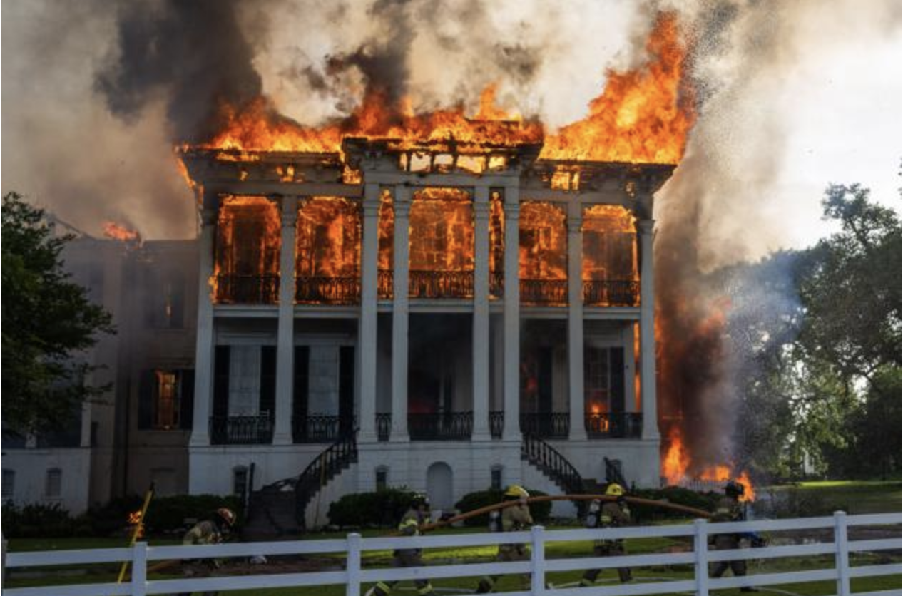 Nottoway Plantation on fire with firefighters in action.